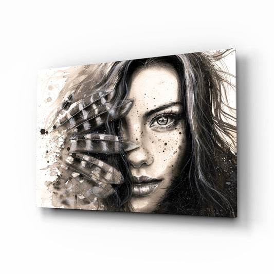 Glass wall art depicting a monochrome portrait of a woman with feather details obscuring half her face, displayed at an angle against white background.