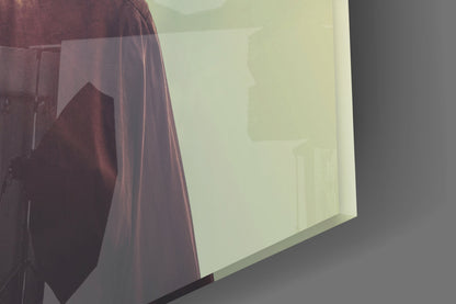 Close-up angled view of translucent frosted glass panel glowing pale yellow-green against dark gray wall and burgundy fabric.