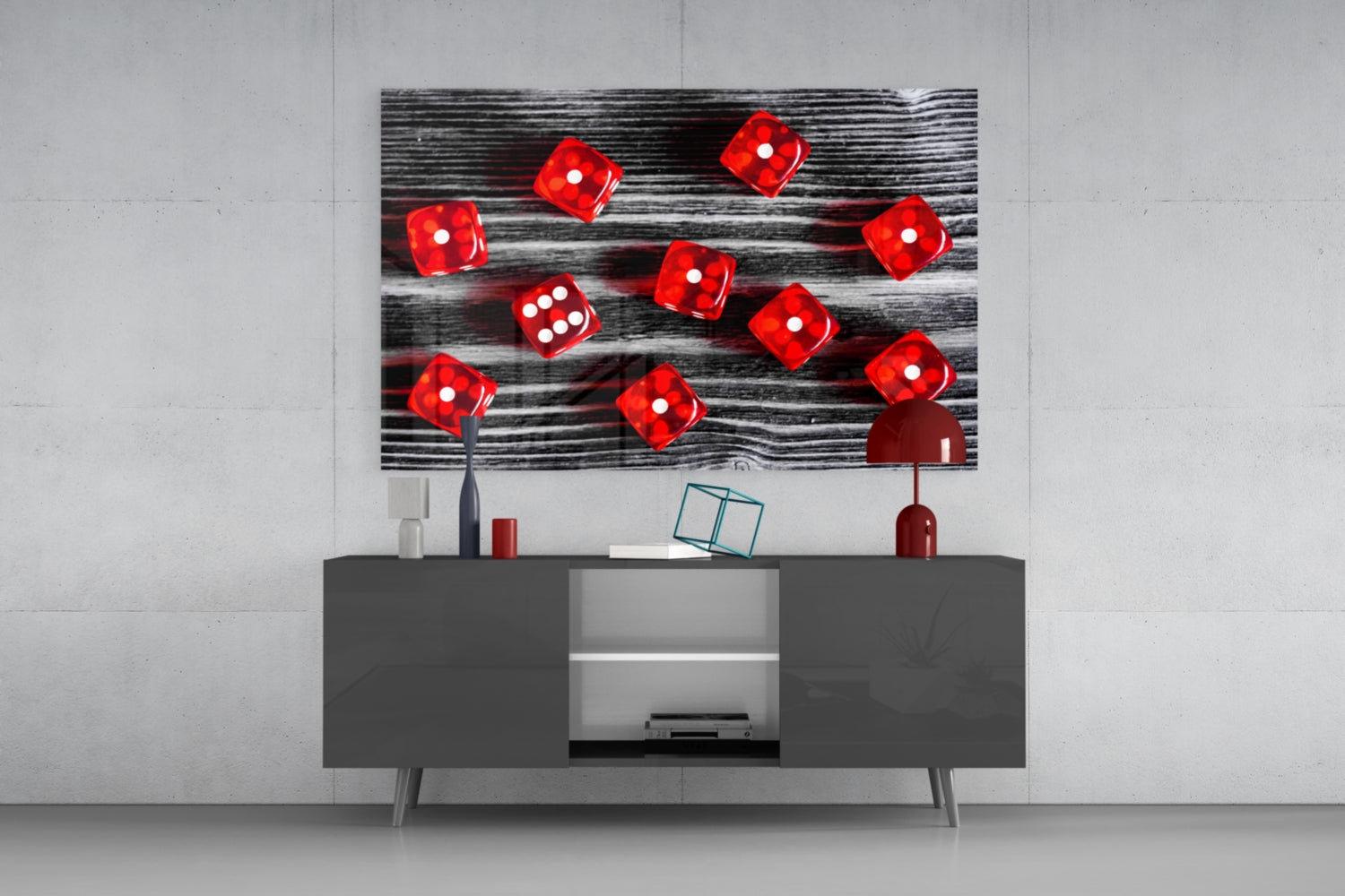 Red dice on black wood grain glass wall art displayed above gray media console in modern interior setting.