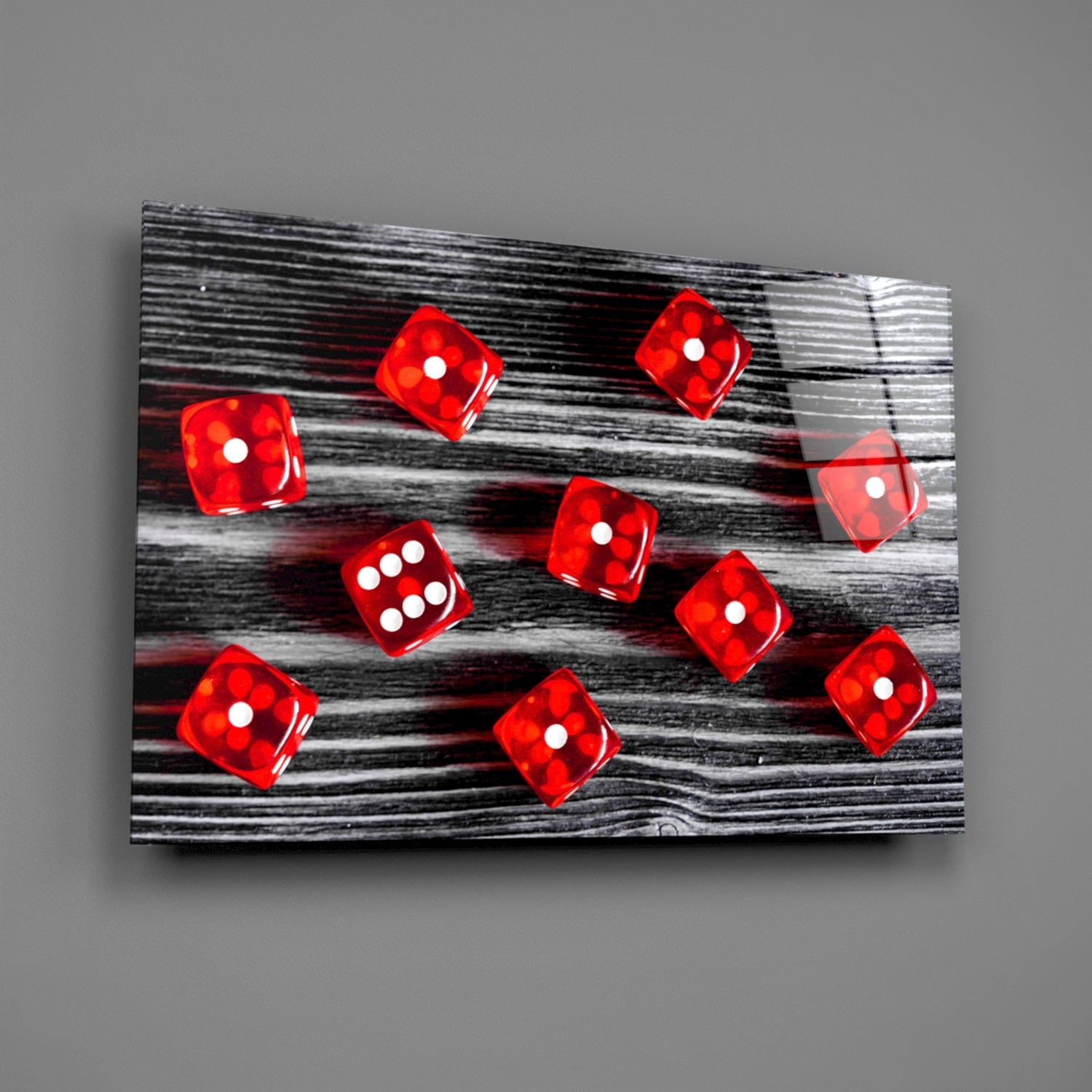 Red translucent dice with white dots scattered on black and white wood grain glass panel, angled perspective view.
