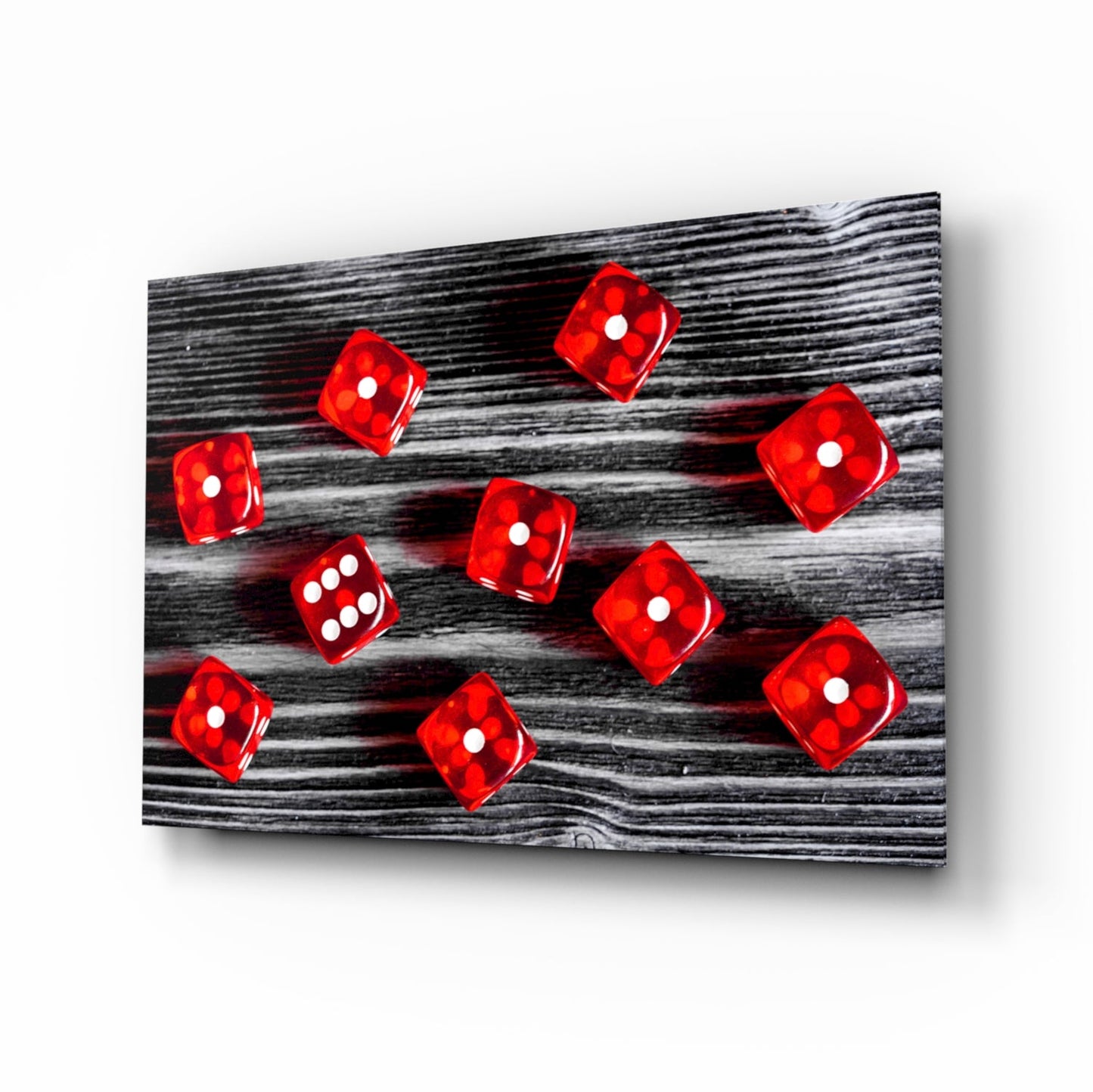 Red translucent dice with white dots scattered across black wood grain textured glass panel, angled perspective view.