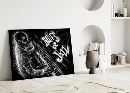 Black and white glass wall art leaning against white wall displays sketched musician with piano and "Blues Jazz" text.