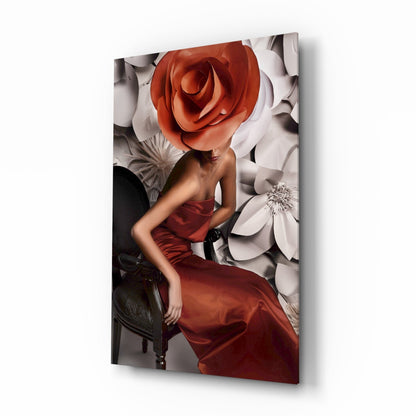 Woman in red dress seated against white and coral floral backdrop, head replaced by large red rose, displayed as glass wall art.