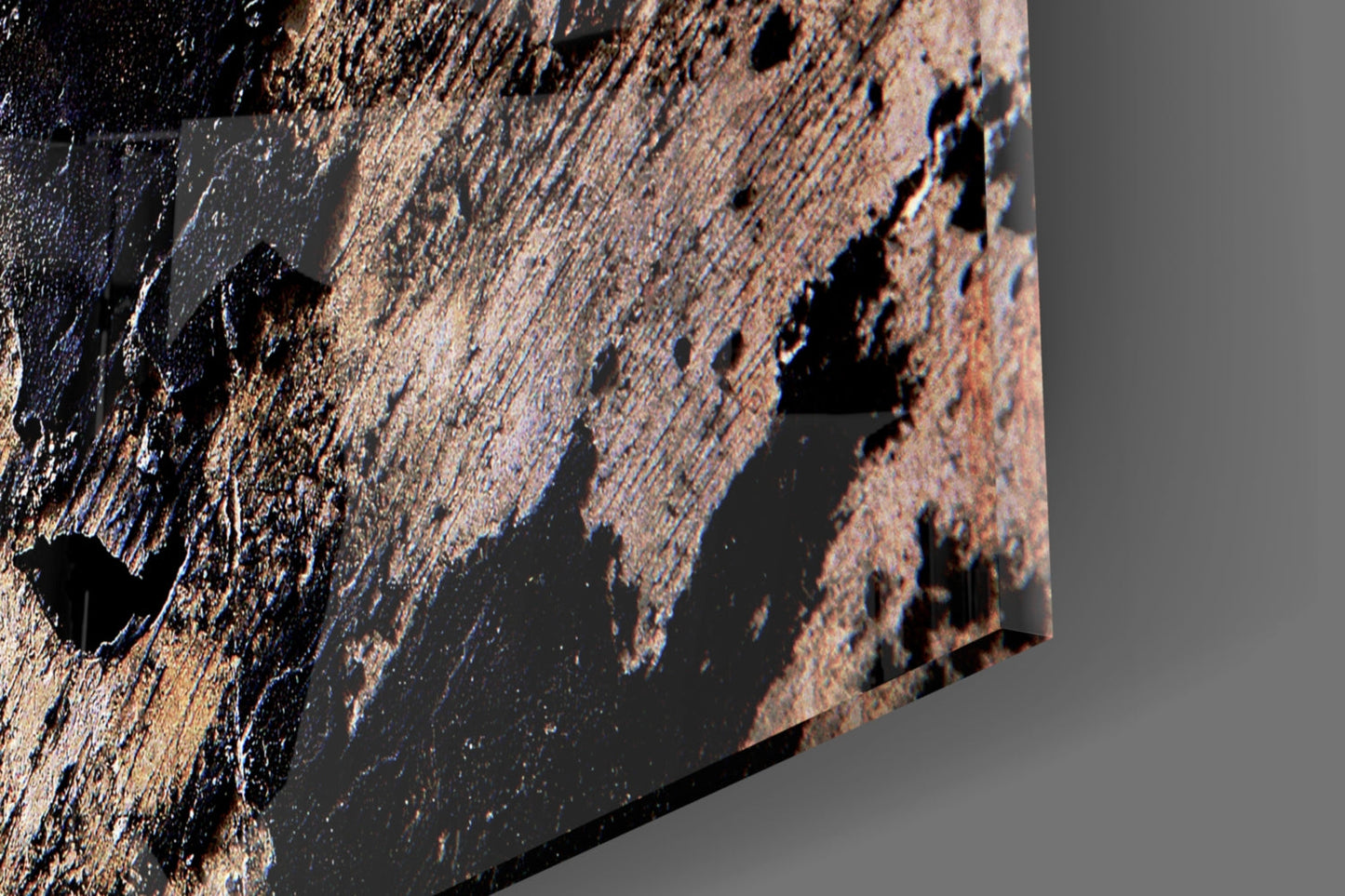 Close-up detail of textured glass surface with brown, tan, and black layered patterns and relief features.