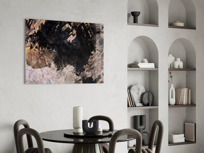 Abstract wall art with black, tan, and cream textured surface hanging above a black round dining table with gray upholstered chairs.