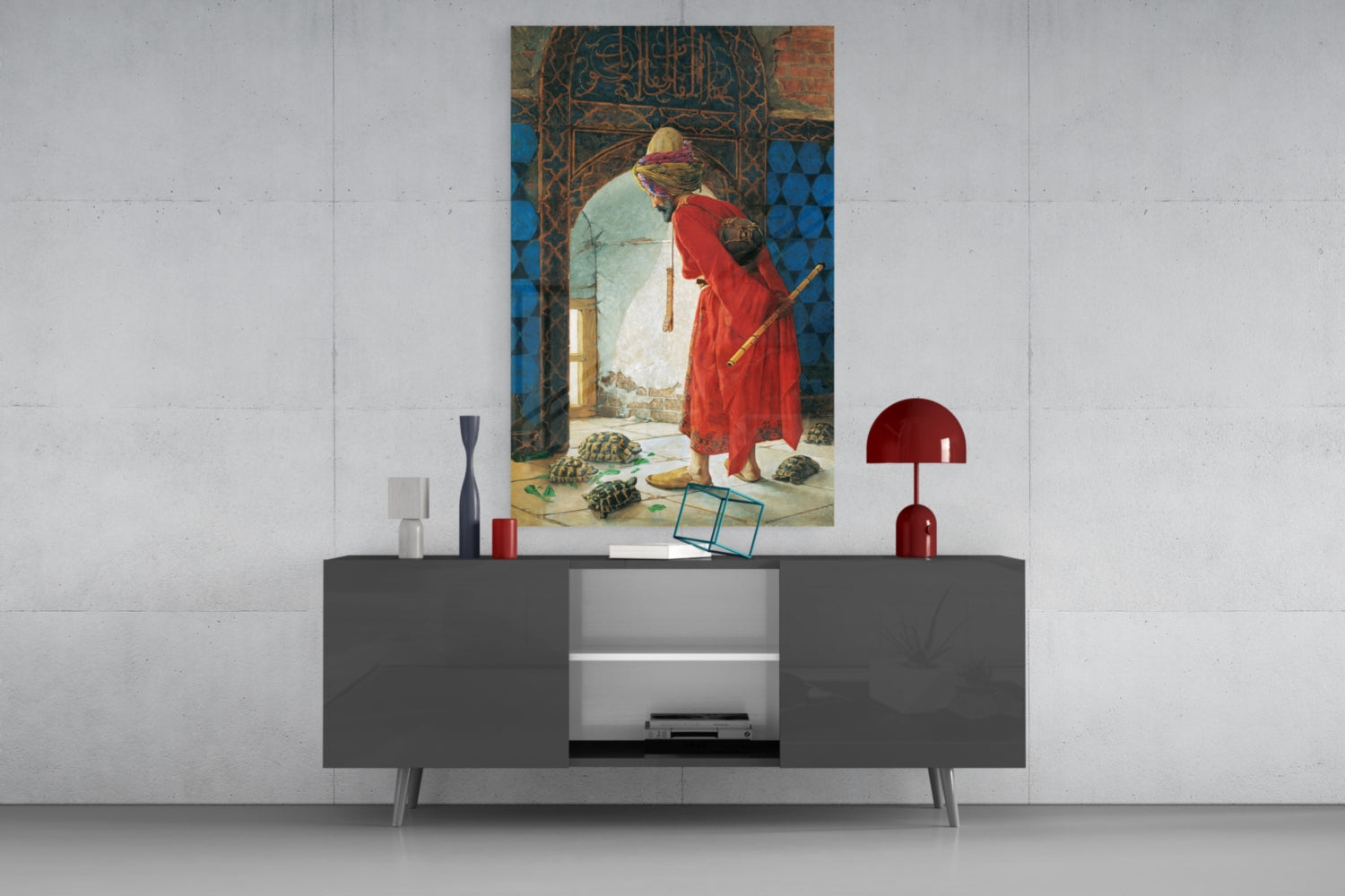 Turtle Trainer Glass Wall Art displayed above gray media console with red lamp and decorative objects against white brick wall.