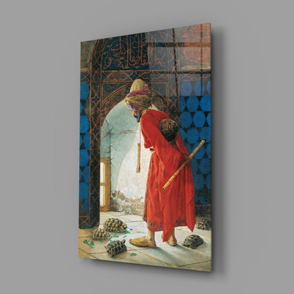 A framed glass wall art print displaying an orientalist painting of a figure in red robes and yellow turban observing tortoises in a blue-tiled courtyard.