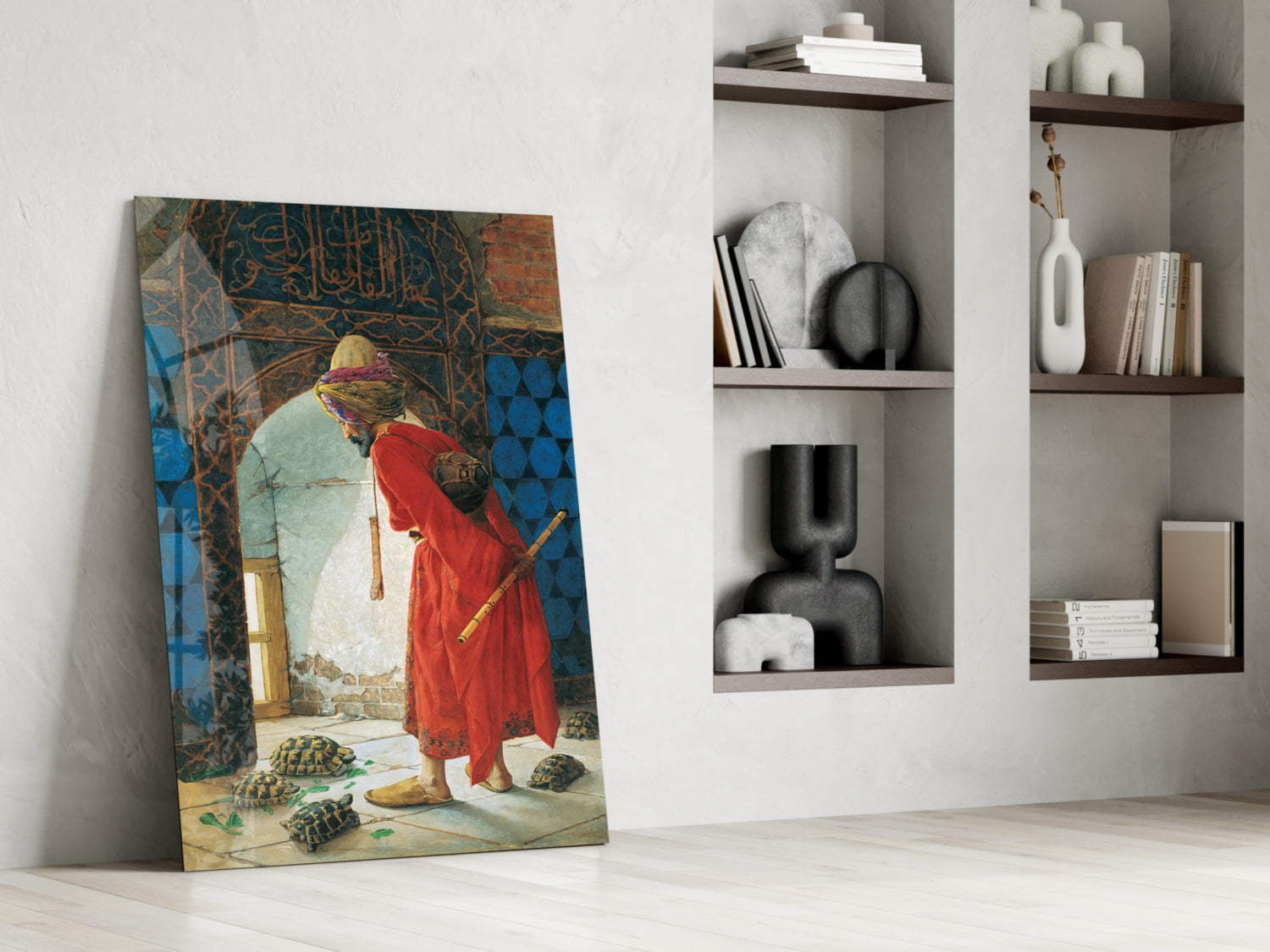 Turtle Trainer glass wall art leaning against white wall beside shelving unit, depicting figure in red robe with yellow headwrap tending tortoises.