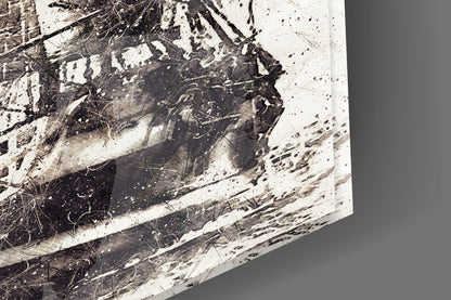 Close-up of glass wall art showing black and white splattered paint texture with fine line details on translucent surface.