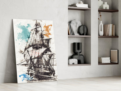 Glass wall art leaning against white wall displays detailed black sailing ship with blue and orange watercolor splashes.