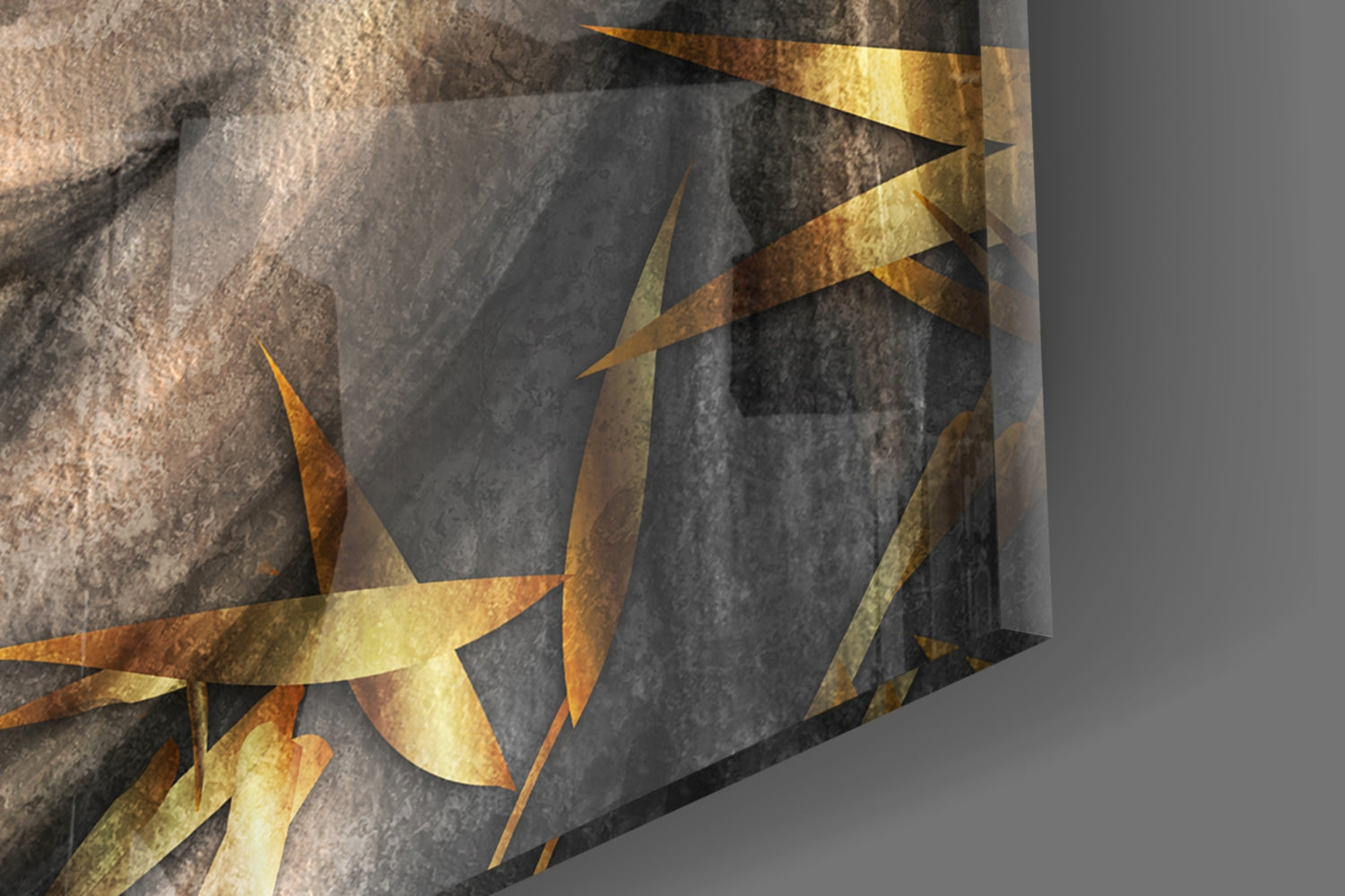 Close-up angled view of textured glass wall art with gold leaf accents overlaying gray stone surface.