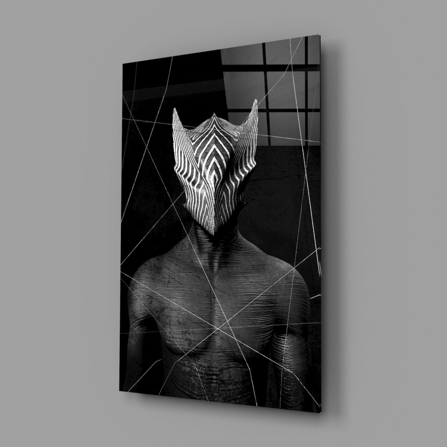 Angled view of black and white glass wall art depicting a figure with striped geometric mask pattern against dark background with linear overlay design.