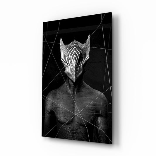 Angled product view of black glass wall art featuring a figure with an intricate white striped facial mask design and geometric line overlay.