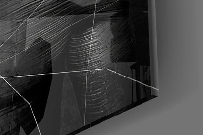 Angled close-up view of gray glass wall art with etched linear patterns and geometric shapes casting shadows.