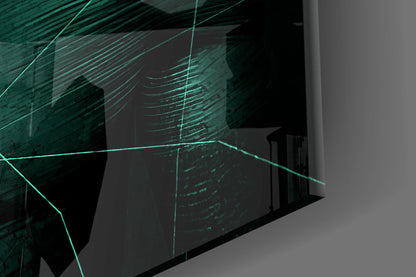 Angled view of emerald green glass wall art with glowing cyan linear patterns mounted on light gray wall.