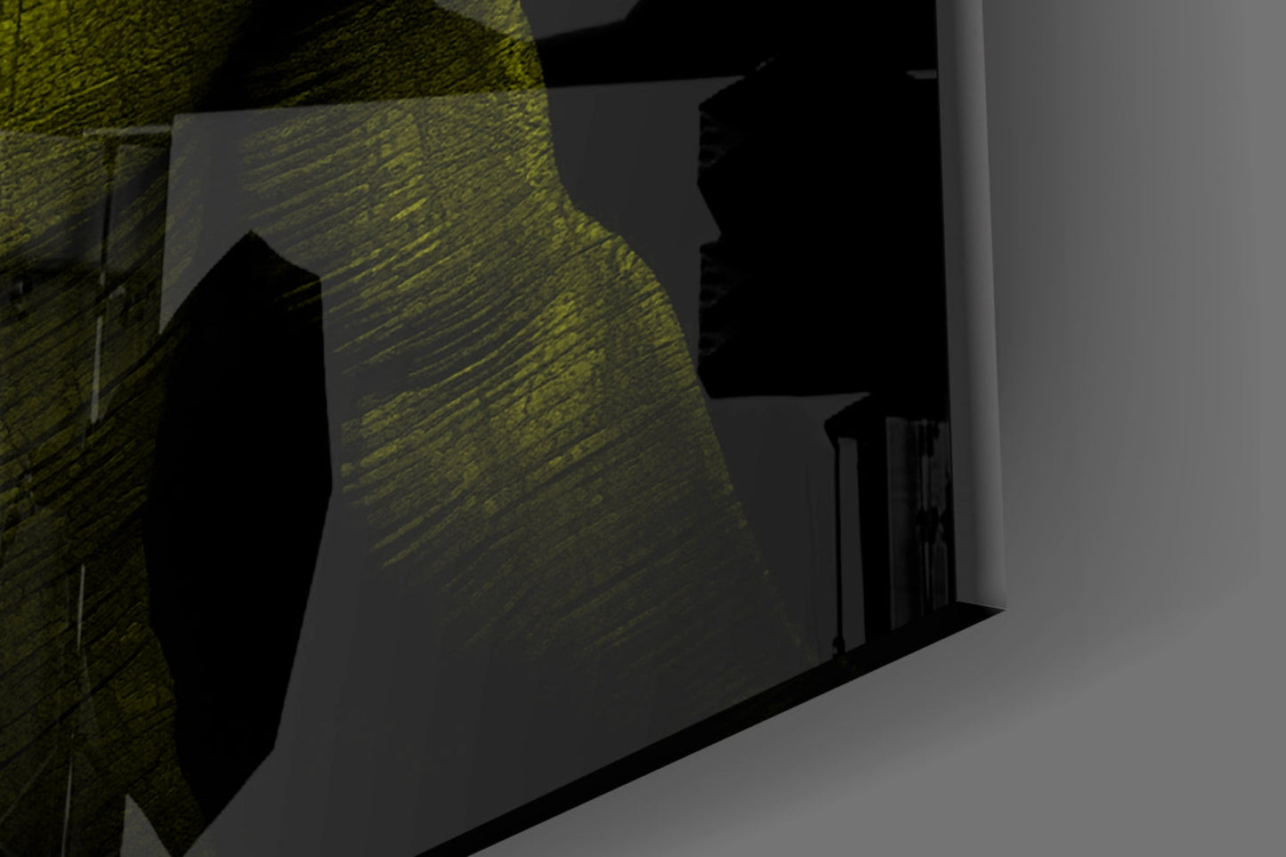 Donnie Yellow Glass Wall Art displayed at an angle showing textured yellow-green glass surface against dark shadows and white walls in interior setting.