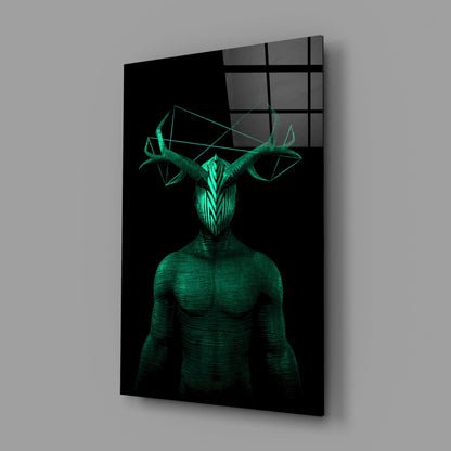 Glass wall art displaying a glowing green humanoid figure with geometric horns against black background, mounted at angle.