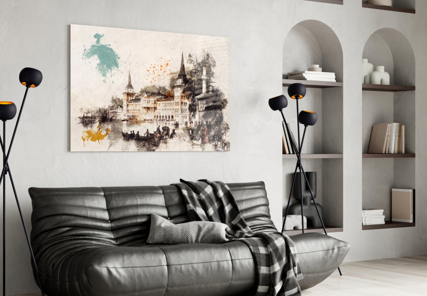 Castle illustration glass wall art with watercolor splashes in teal, orange, and gray tones displayed above a black leather sofa.