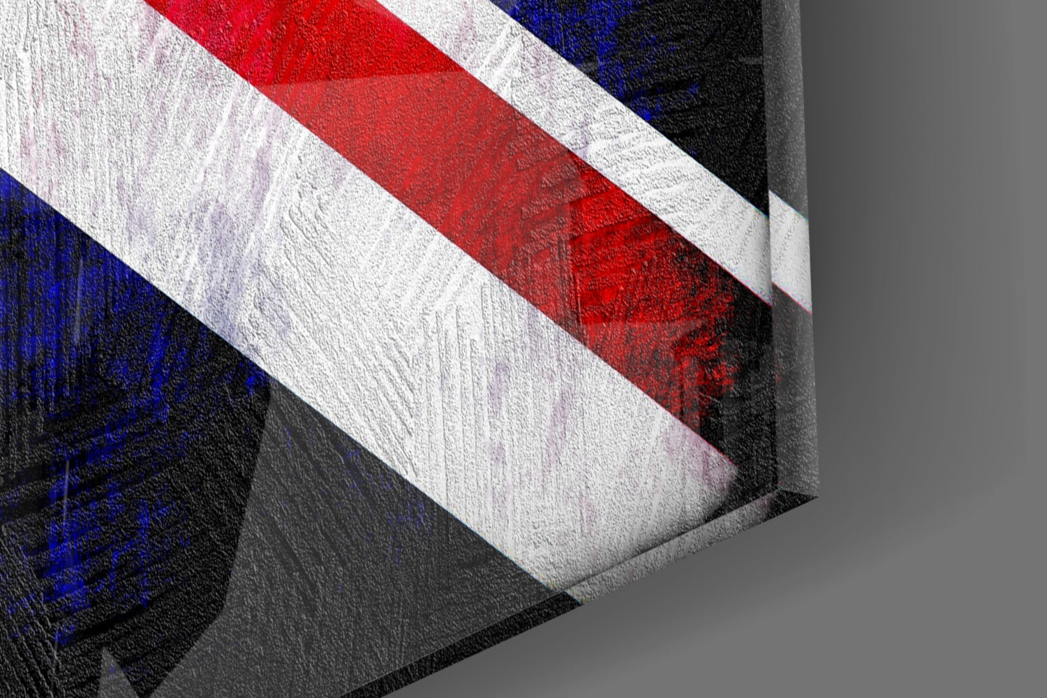 Close-up angled view of Union Jack glass wall art showing red, white, and blue diagonal stripes with textured glass surface against gray background.