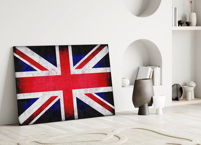 British flag glass wall art leaning against white wall in minimalist room with shelving and decorative objects.