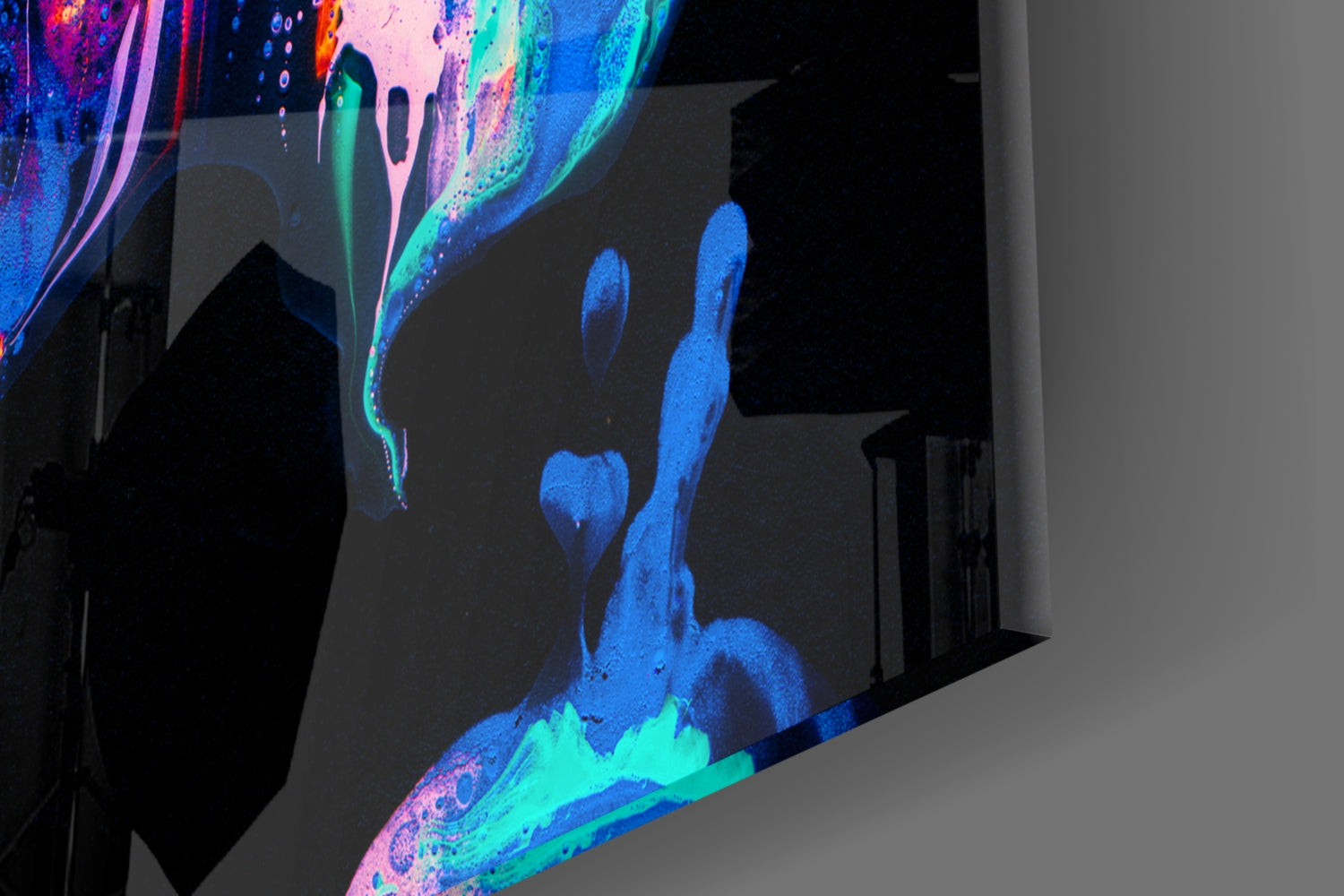 Neon glass wall art with glowing blue, cyan, and pink flame designs illuminated against dark interior wall.
