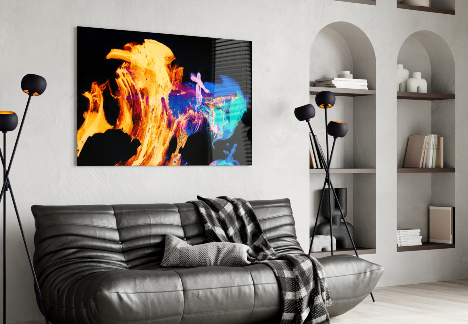 Modern living room with black leather sofa displaying vibrant flames glass wall art above, featuring orange and blue thermal imagery.