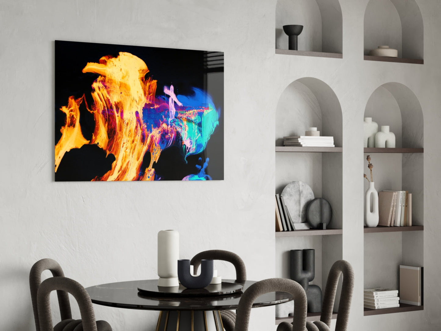 Vibrant glass wall art featuring yellow and orange flames with blue accents displayed above a black dining table in a minimalist interior.