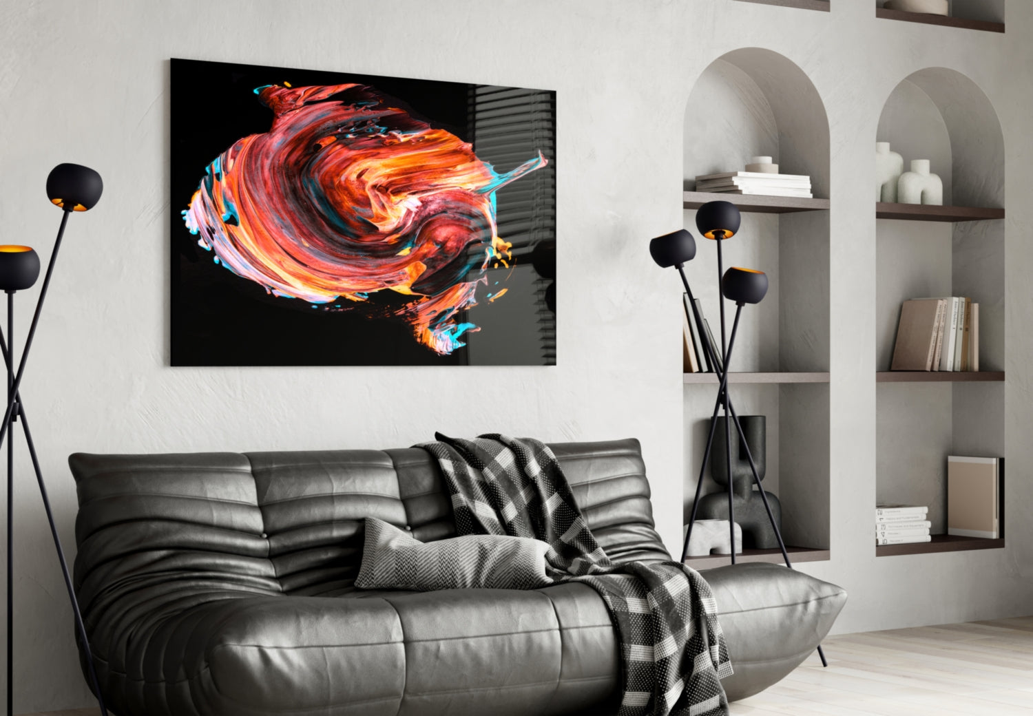 Modern living room with black leather sofa displaying vibrant red and orange abstract glass wall art above.