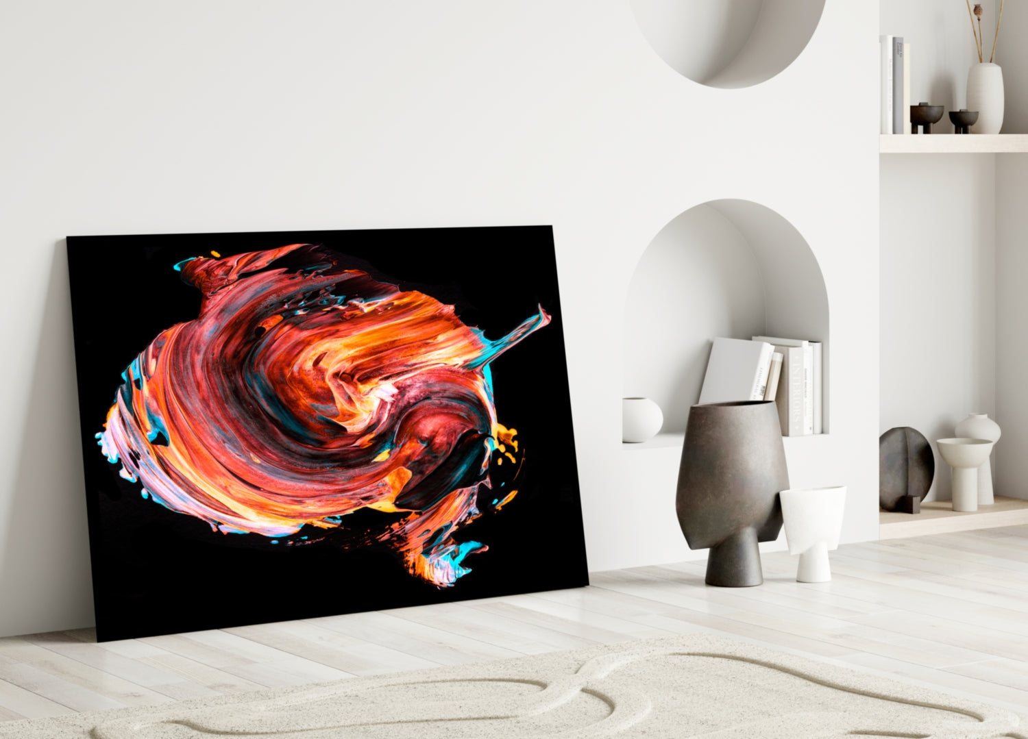 Black framed abstract art featuring swirling red, orange, and blue brushstrokes leaning against white wall with decorative objects.