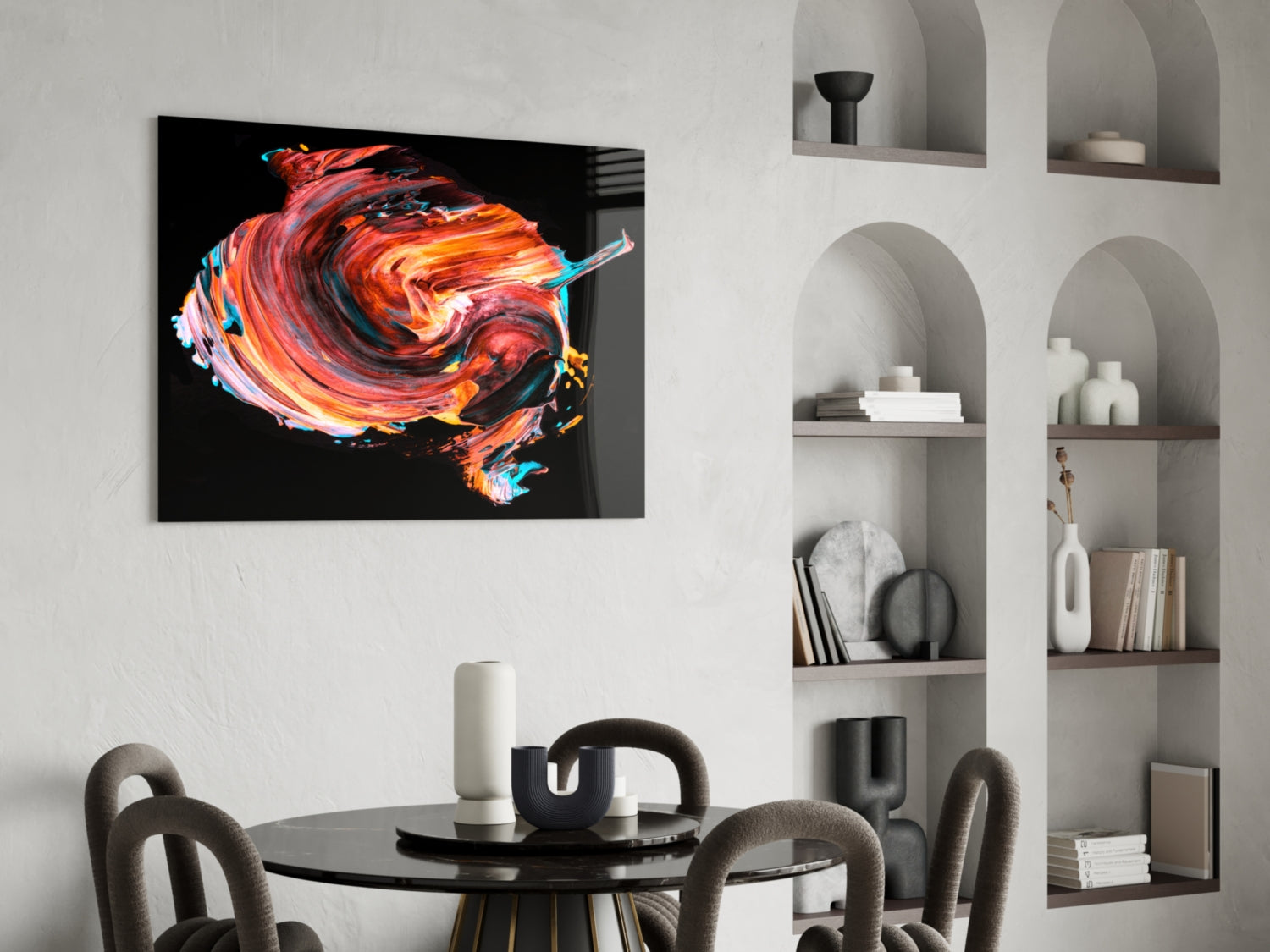Vibrant red and orange swirling glass artwork displayed on white wall above black dining table with gray chairs.