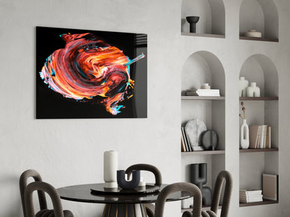 Vibrant red and orange swirling glass artwork displayed on white wall above black dining table with gray chairs.