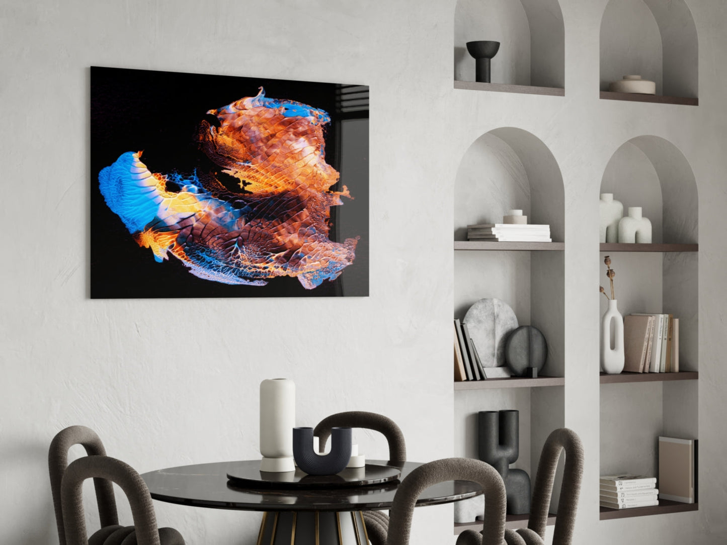 Vibrant abstract glass wall art with blue, orange, and gold tones displayed above a dining table in a modern interior.