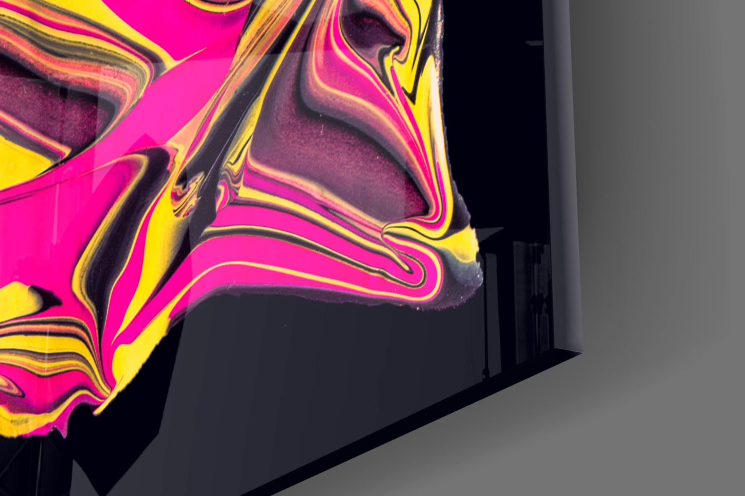 Close-up angled view of vibrant yellow, magenta, and black swirled glass wall art panel with liquid marble texture.