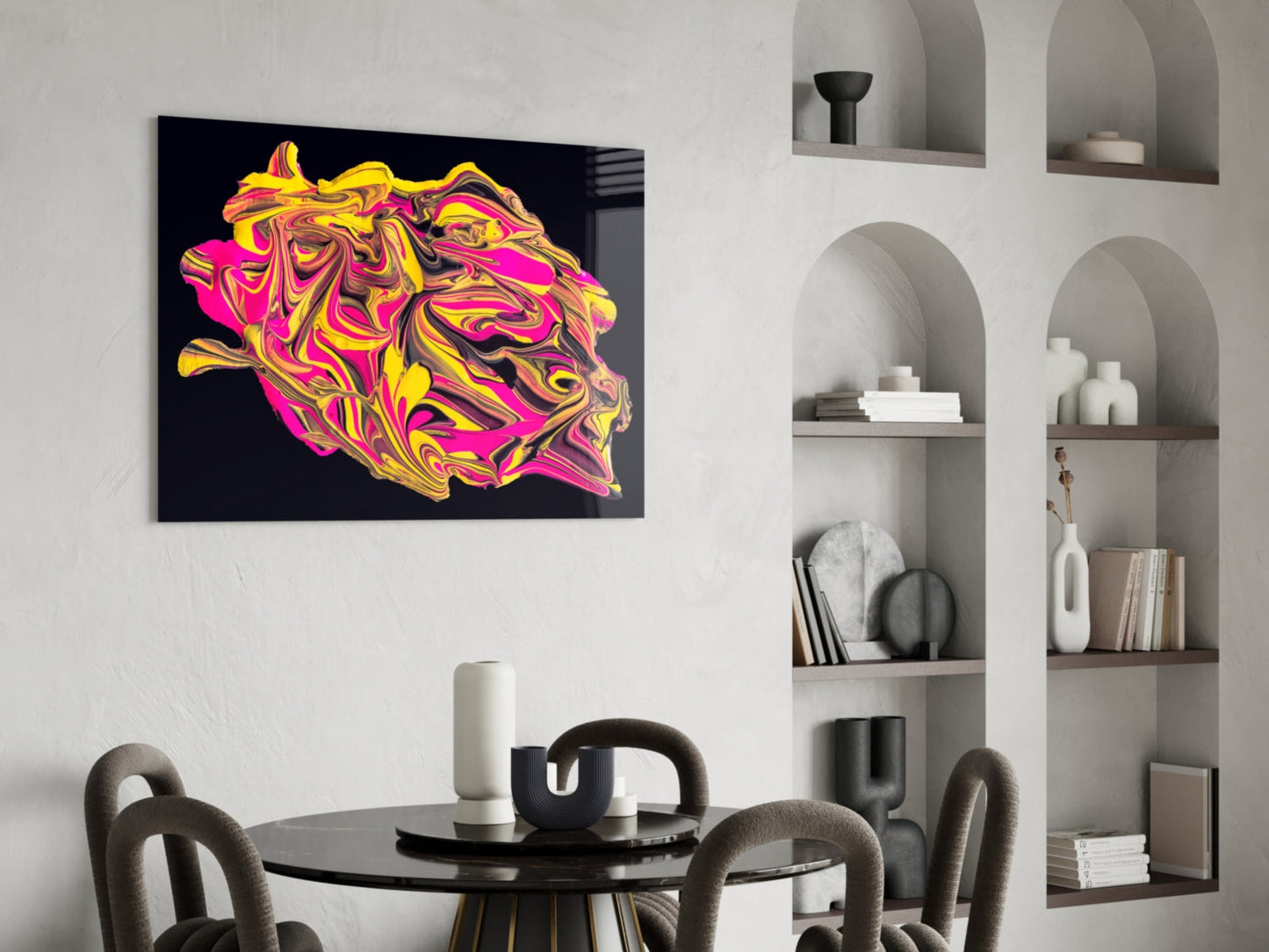 Vibrant yellow, pink, and magenta swirled glass art displayed above a black dining table in a modern interior with built-in shelving.