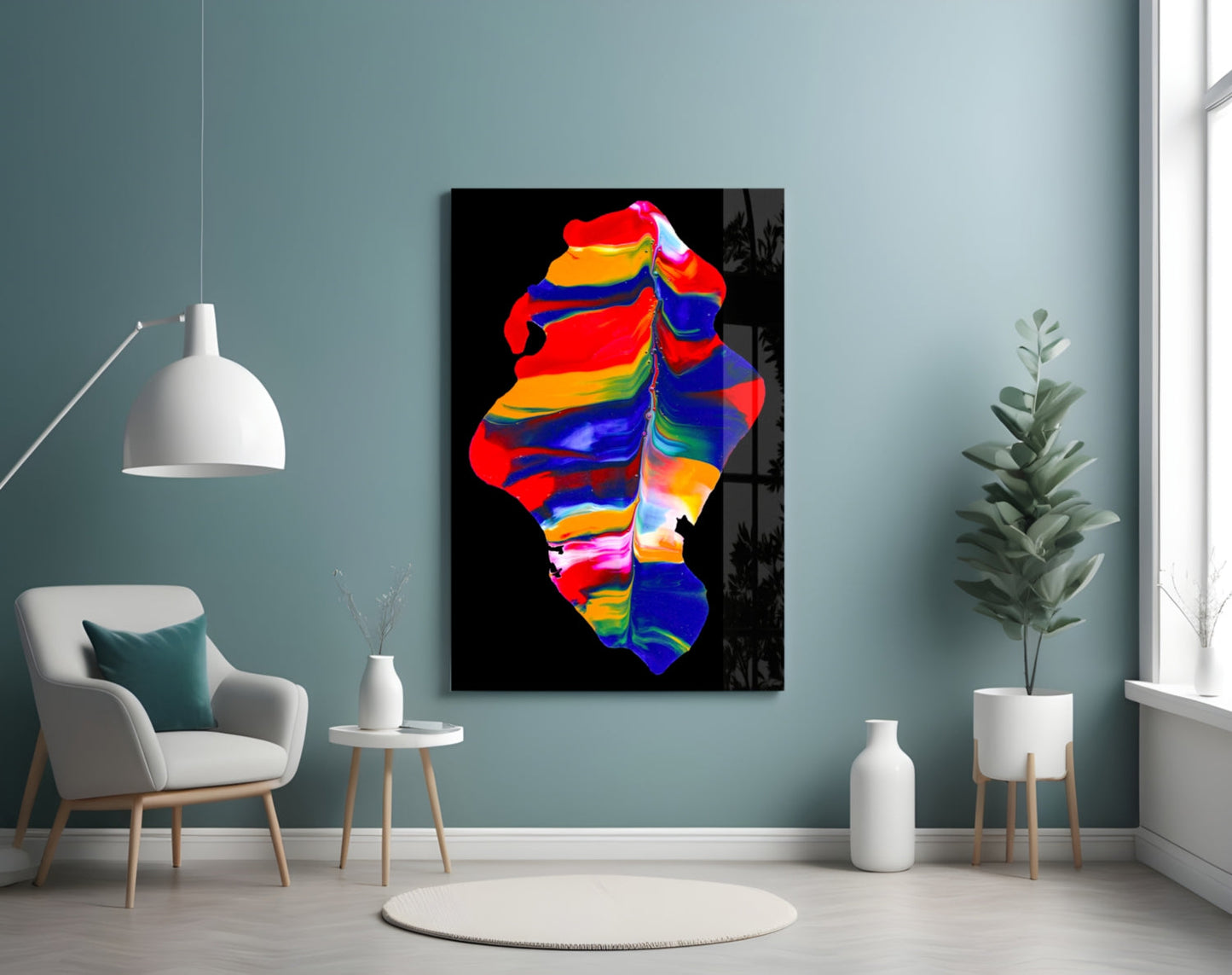 Colorful abstract glass wall art in vibrant rainbow hues displayed in a modern living room with teal walls, white furniture, and potted plants.