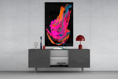 Vibrant abstract glass wall art in magenta, orange, and blue displayed above a gray media console in a modern interior setting.