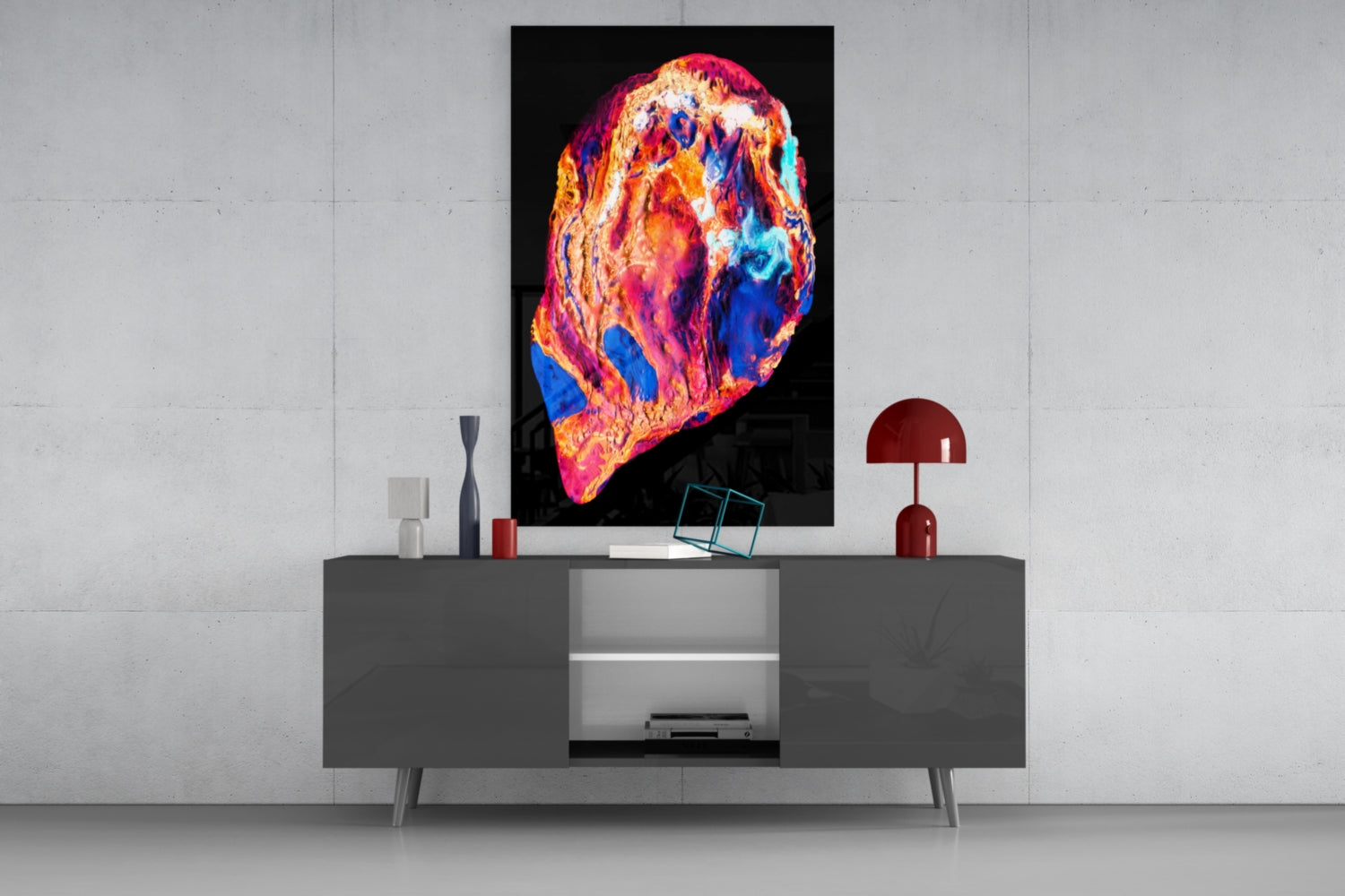 Vibrant thermal-map style glass art with red, orange, pink, and blue hues displayed above a gray media console in a modern interior setting.