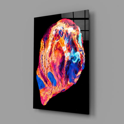 Angled view of a black glass panel displaying a vibrant, multicolored lava formation with blues, oranges, reds, and whites against a gray background.