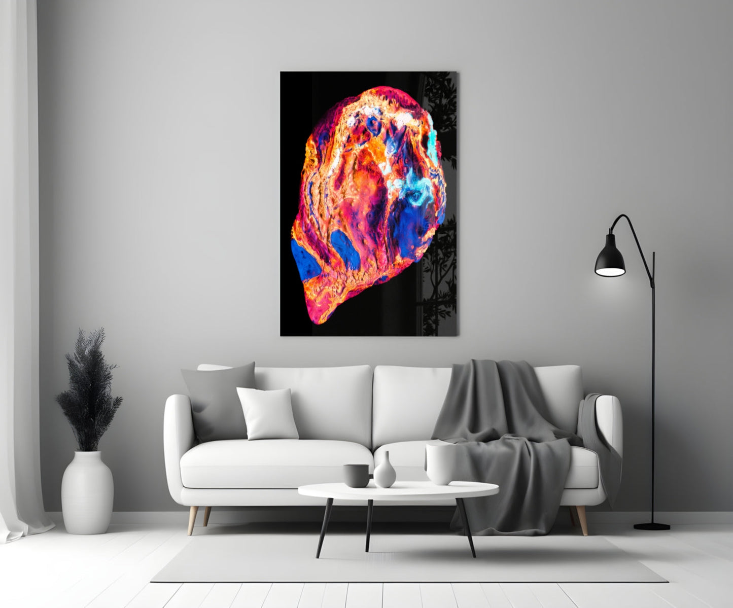 Colorful lava glass wall art in vibrant reds, oranges, yellows, and blues hanging above a white sofa in a modern living room interior.