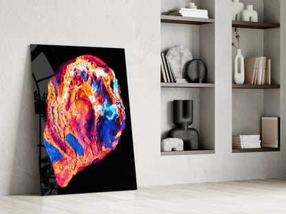 Vibrant lava glass wall art leaning against white wall beside built-in shelving with decorative objects.