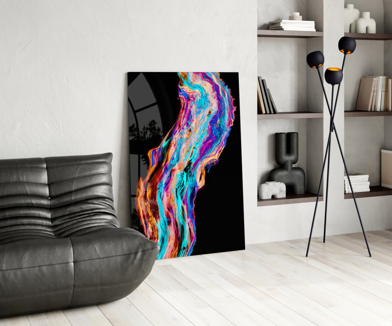 Colorful fluid glass wall art with neon pink, blue, orange, and cyan swirls displayed in a modern living room next to a gray leather sofa.