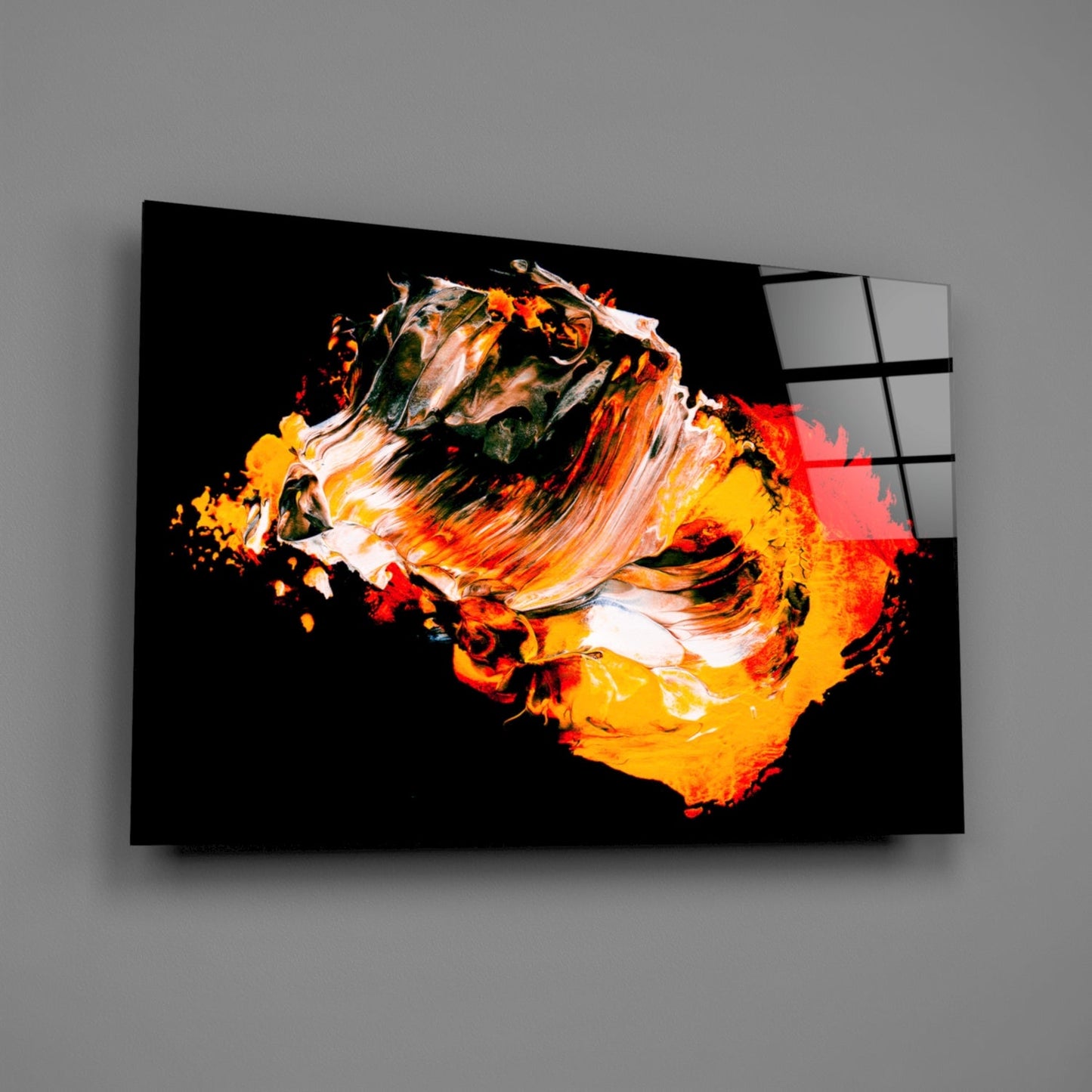 Modern glass wall art featuring vibrant orange, yellow, and white paint strokes on black background, displayed at an angle.