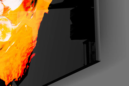 Close-up of vibrant yellow and orange glass wall art with red accents mounted on gray wall interior.