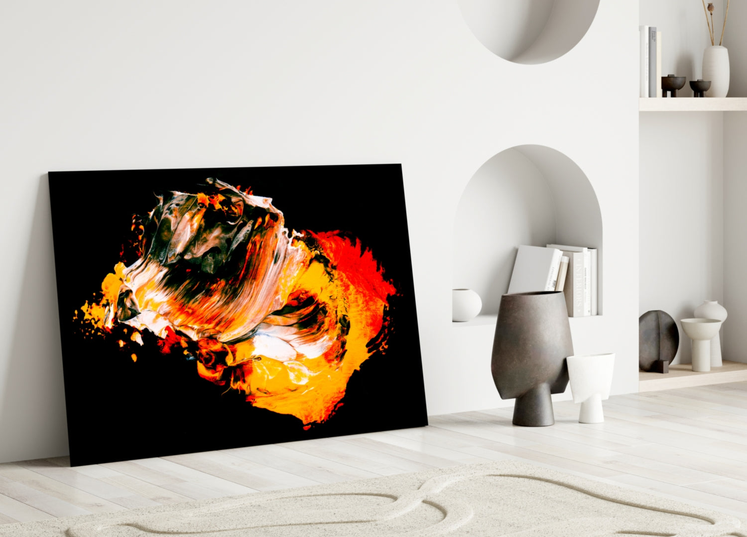 Vibrant abstract glass wall art with orange, yellow, and red brushstrokes on black leaning against white minimalist shelving.