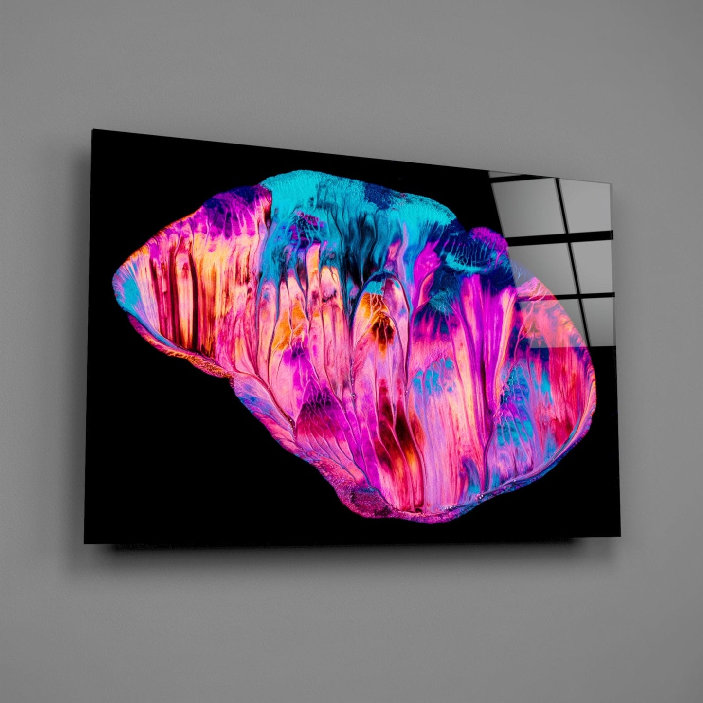 Vibrant neon pink, cyan, and yellow abstract glass wall art mounted on gray wall, displayed at angle.