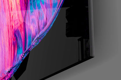 Angled view of vibrant pink and blue gradient glass art panel mounted on white wall, showing fluid color transitions and reflective surface.
