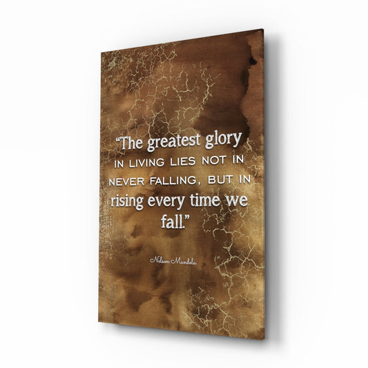 Angled view of brown textured glass wall art displaying Nelson Mandela quote about greatest glory in rising after falling.