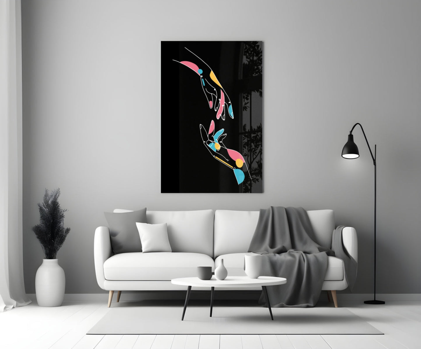 Colorful abstract hands glass wall art displayed above white sofa in modern living room interior.