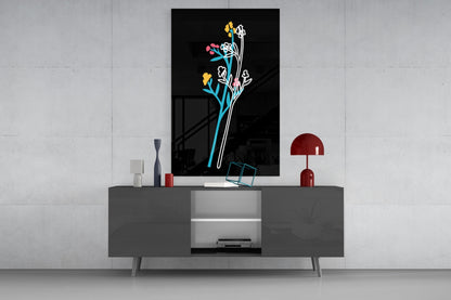 Abstract colorful flowers glass wall art with neon-style lines displayed above gray media console in modern interior setting.