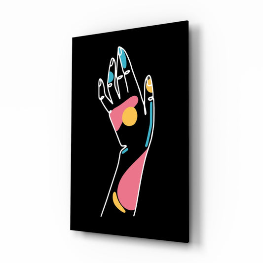 Angled perspective view of glass wall art displaying an open palm with white outline and colored geometric shapes in pink, teal, and yellow against black background.